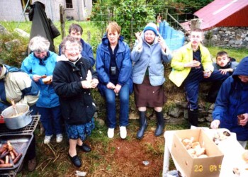 A group having a barbecue. It looks cold.