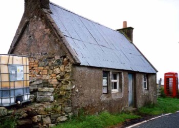A building with a tin roof with a phone box outside