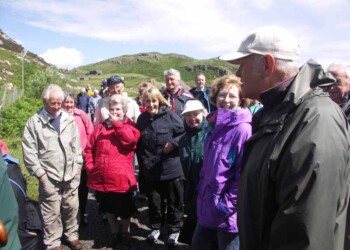 Roddy relates some his early memories of Calbost to the assembled audience Man talking with smiling group listening