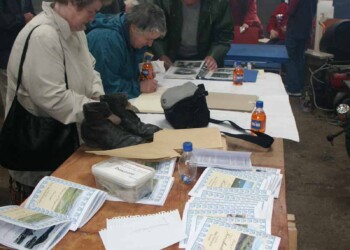 Books and exhibits on show. People looking at books on a table