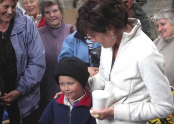Adults standing around a boy