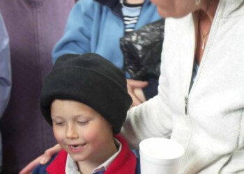 Adults standing around a boy