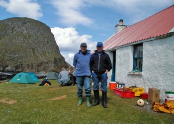 Roddy and Allan on the Shiants July 2000 2 men in foreground standing in front of tents beside a building