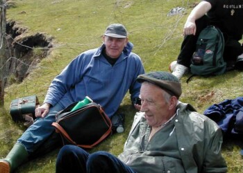 Roddy and Rob relaxing on the Shiants 3 people sitting on grass