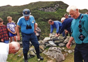 Building a memorial cairn into which a bible is inserted within the cairn. Building a cairn at Steimreway