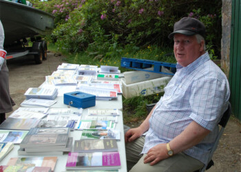 Donnie at the book sales tables Man sitting at a table selling books