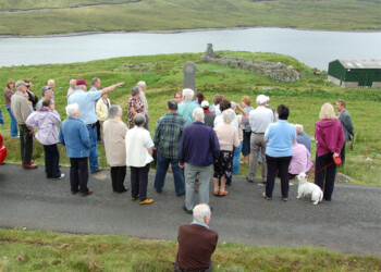 Ken Roddy addresses the group at Seaforth Head Man talking to group with his arm raised with loch in background