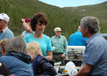 Visitor from afar takes in the scene Group standing in front of hills with food cooking