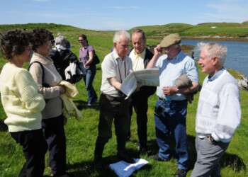 Group examining a large document, possibly a map