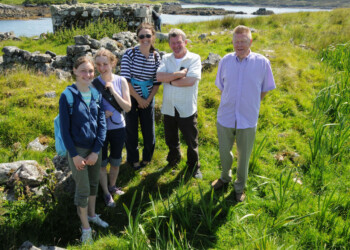 Group standing in the sunshine in front of ruin
