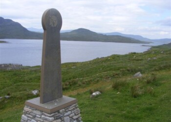 A monument with loch and hills beyond